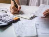 A young woman checking bills, taxes, bank account balance and calculating expenses for her small business.