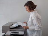 woman checking document at scanner printer fax machine