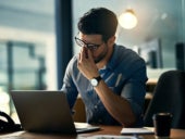 Shot of a young professional experiencing stress during a late night at work.