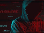 Ransomware concept with faceless hooded male person, low key red and blue lit image and digital glitch effect.