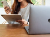 A woman holding Apple devices.