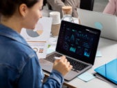 Person working using a laptop with data analytics software on display.